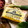 Grandma's Frozen Noodles wide egg noodles 16oz package surrounded by fresh ingredients. 